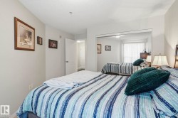 Bedroom featuring a full-wall mirrored closet, light neutral wall paint, and overhead lighting - 