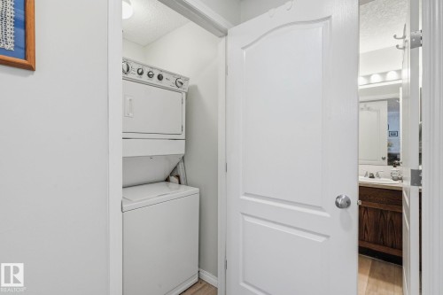 Dedicated laundry area featuring a stacked washer and dryer unit - 1223 9363 Simpson Dr, Edmonton, AB 