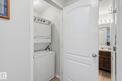 Dedicated laundry area featuring a stacked washer and dryer unit - 