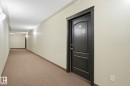 Building corridor with light beige walls and textured ceiling - 1223 9363 Simpson Dr, Edmonton, AB 