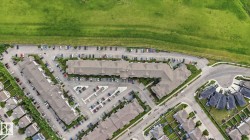 Aerial perspective of a multi-unit residential complex featuring extensive surface parking - 