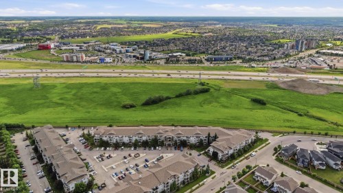Aerial perspective showcasing multiple residential buildings with varying rooflines, extensive parking areas, and mature landscaping - 1223 9363 Simpson Dr, Edmonton, AB 