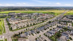 Aerial perspective showcasing a mixed-use development with residential properties, retail centers, commercial spaces, and ample parking - 