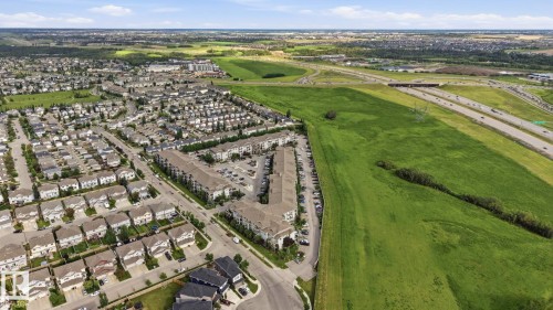 Aerial perspective of a residential community featuring single-family homes and multi-story apartment buildings - 1223 9363 Simpson Dr, Edmonton, AB 