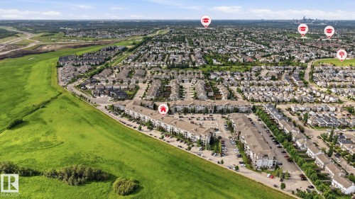 Expansive aerial perspective showcasing a residential development with an abundance of detached homes and multi-family buildings - 1223 9363 Simpson Dr, Edmonton, AB 