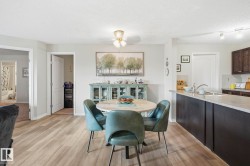 Open concept living area featuring wood-finish flooring, a ceiling-mounted light fixture, and a kitchen island with an undermount sink - 