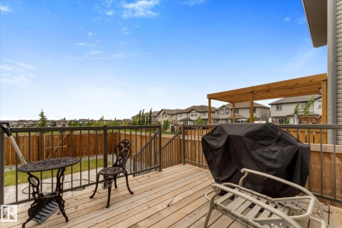 Spacious wood deck featuring a wooden pergola and metal railing - 92 Elm Street, Fort Saskatchewan, AB 