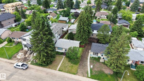 Neighborhood aerial featuring multiple residential properties with pitched roofs, mature landscaping, and established trees - 10924 154 Street, Edmonton, AB 