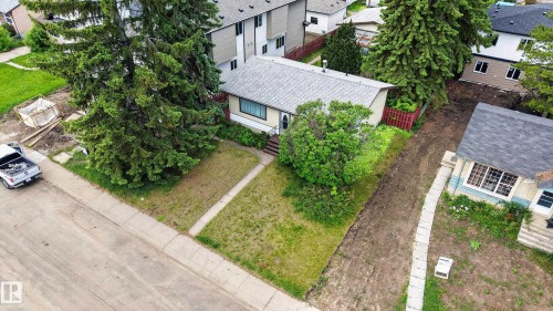 Single-story residence featuring a gray shingle roof, light-colored siding, and a prominent front window - 10924 154 Street, Edmonton, AB 