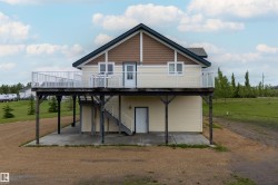 Exterior featuring a multi-level design with a prominent second-story deck, horizontal siding, and gable accents - 
