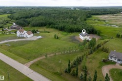 Aerial perspective showcasing a sprawling property bordered by mature tree lines and expansive green spaces - 