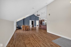 Spacious interior featuring wood-finish flooring, vaulted ceilings, and a built-in wood-burning stove - 