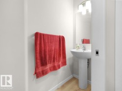 Pedestal sink with chrome faucet, mirror, wall-mounted light fixture, and wood-finish flooring - 