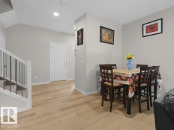 Light wood-finish flooring extends throughout the main level - 