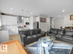 Contemporary kitchen with white shaker cabinetry, stainless steel appliances, subway tile backsplash, and a central island with countertop seating - 