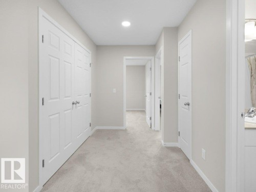Neutral-toned hallway featuring light gray carpeting and white trim - 2039 13 Avenue, Edmonton, AB 