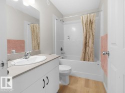Bathroom featuring a white vanity with an integrated sink, chrome faucet, and light-toned countertop - 