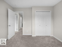 Plush carpeted flooring with light neutral wall tones, a paneled door, and bi-fold closet doors - 