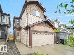 Contemporary two-story residence featuring light-toned siding and dark brown trim accents - 