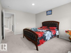 Carpeted bedroom featuring light neutral wall paint, recessed lighting, and a doorway opening to a hallway - 