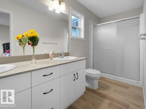 Dual sink vanity with white cabinetry and dark hardware, set against light neutral walls - 2039 13 Avenue, Edmonton, AB 