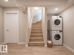 Laundry area featuring a stacked washer and dryer, wood-finish flooring, and recessed ceiling lighting - 