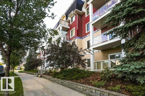 Multi-story building featuring red and beige exterior siding with multiple private balconies - #117 226 Macewan Sw, Edmonton, AB - Outdoor