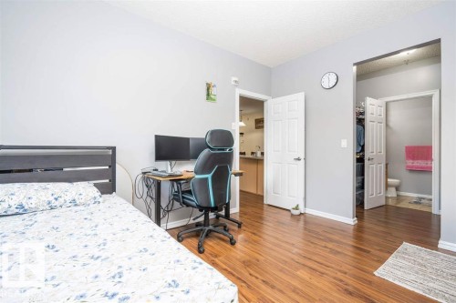 Spacious interior with wood-finish flooring, light grey painted walls, and white trim - #117 226 Macewan Sw, Edmonton, AB - Indoor