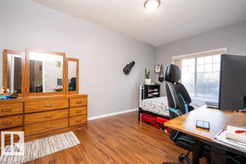 Room featuring wood-finish flooring, a window with horizontal grids, and a ceiling-mounted light fixture - #117 226 Macewan Sw, Edmonton, AB - Indoor