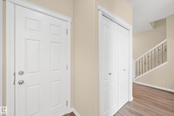 Entryway featuring wood-finish flooring, a paneled door with chrome hardware, and a closet with bifold doors - 