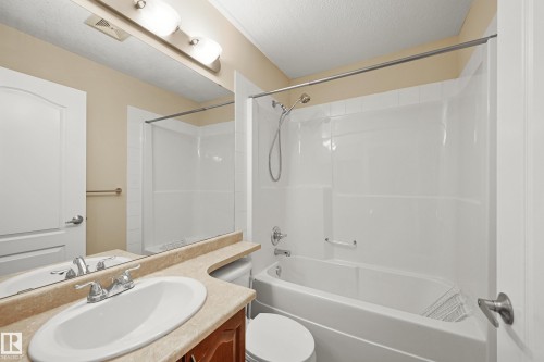 Full bathroom featuring a white porcelain tub and shower combination with chrome fixtures - 11544 11 Avenue, Edmonton, AB 