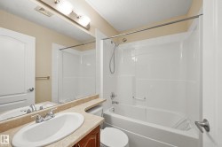 Full bathroom featuring a white porcelain tub and shower combination with chrome fixtures - 