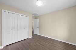 Interior room featuring wood-finish flooring, light beige wall paint, and white trim - 