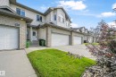 Townhome exterior featuring light-colored siding and brick accents - 11544 11 Avenue, Edmonton, AB 
