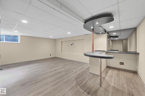 Finished basement space featuring a built-in bar with a mirrored backsplash - 11544 11 Avenue, Edmonton, AB 
