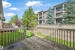 Spacious outdoor wood deck with railing overlooking a green lawn - 