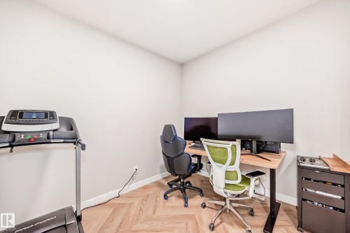 Interior room featuring light-toned walls and wood-finish flooring with a herringbone pattern - 4231 206 Street, Edmonton, AB 