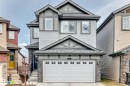 Three-story residence featuring light gray horizontal siding, dark gray trim, and stone veneer accents - 4231 206 Street, Edmonton, AB 