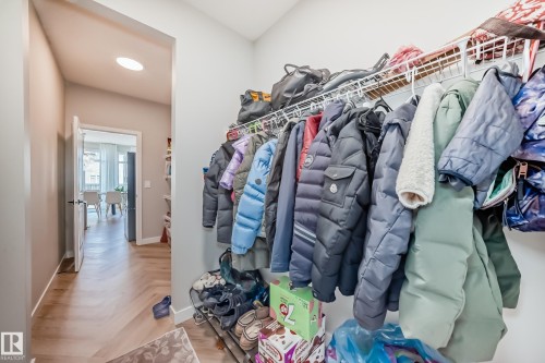 Entryway featuring chevron wood-finish flooring, recessed ceiling lighting, and a closet with wire shelving - 4231 206 Street, Edmonton, AB 