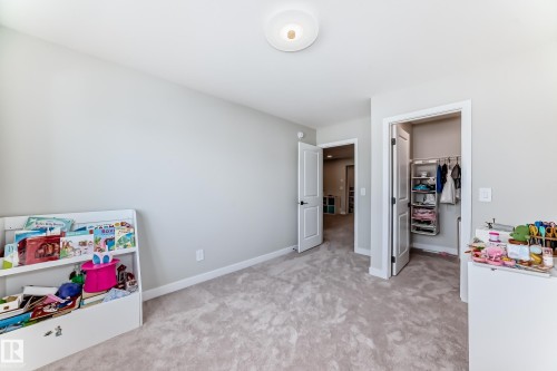Carpeted room featuring light gray wall paint, white baseboards, and a flush-mount ceiling light - 4231 206 Street, Edmonton, AB 