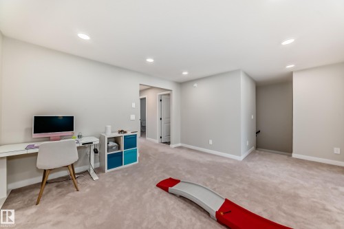 Spacious room featuring neutral carpeting, recessed lighting, light gray wall tones, and white trim - 4231 206 Street, Edmonton, AB 