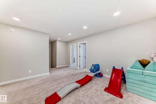 Spacious carpeted room featuring recessed lighting and light gray wall tones - 4231 206 Street, Edmonton, AB 