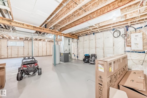 Unfinished basement featuring exposed wood joists, insulated walls, and a light gray painted concrete floor - 4231 206 Street, Edmonton, AB 