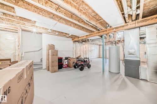 Unfinished basement space featuring exposed wood joists, a painted concrete floor, and visible insulation along perimeter walls - 4231 206 Street, Edmonton, AB 