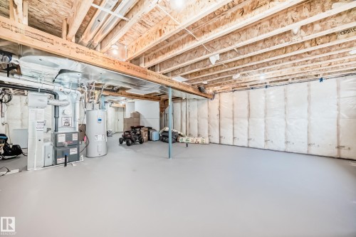 Unfinished basement featuring exposed wood joists, a concrete floor, insulated perimeter walls, a water heater, and a furnace - 4231 206 Street, Edmonton, AB 