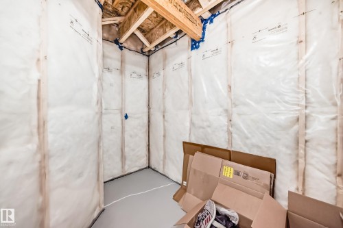 Unfinished room featuring exposed ceiling joists and insulated walls with vapor barrier - 4231 206 Street, Edmonton, AB 