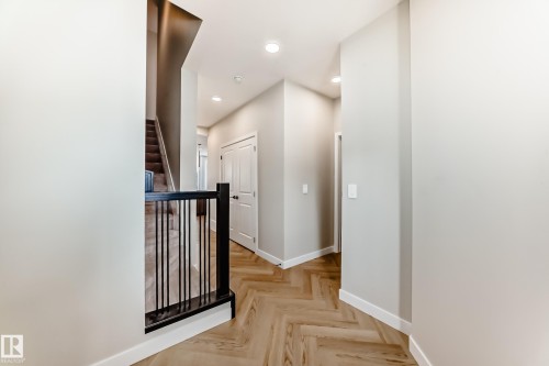 Herringbone wood-finish flooring extending through the hallway - 4231 206 Street, Edmonton, AB 