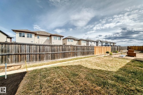 Expansive backyard with a full perimeter fence, featuring a mix of mature and new wood fencing - 4231 206 Street, Edmonton, AB 