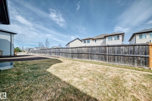 Expansive backyard space featuring a wooden privacy fence, a dedicated gravel area, and a grassy lawn - 4231 206 Street, Edmonton, AB 