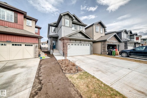 Two-story detached residence featuring a multi-textured facade with gray siding and stacked stone accents - 4231 206 Street, Edmonton, AB 